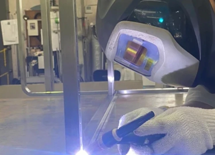 金属パイプの表面をグラインダーで研磨し、火花が飛び散る加工作業の様子。