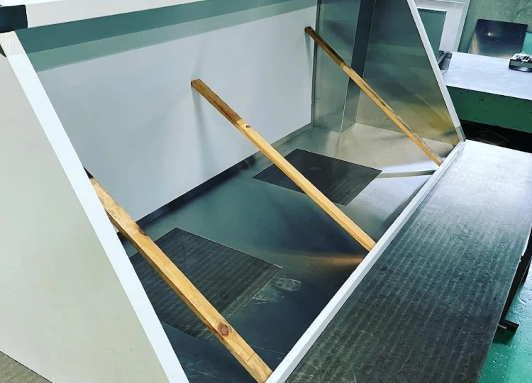 作業台の上で金属フレームを溶接し、組み立て作業を行っている様子。