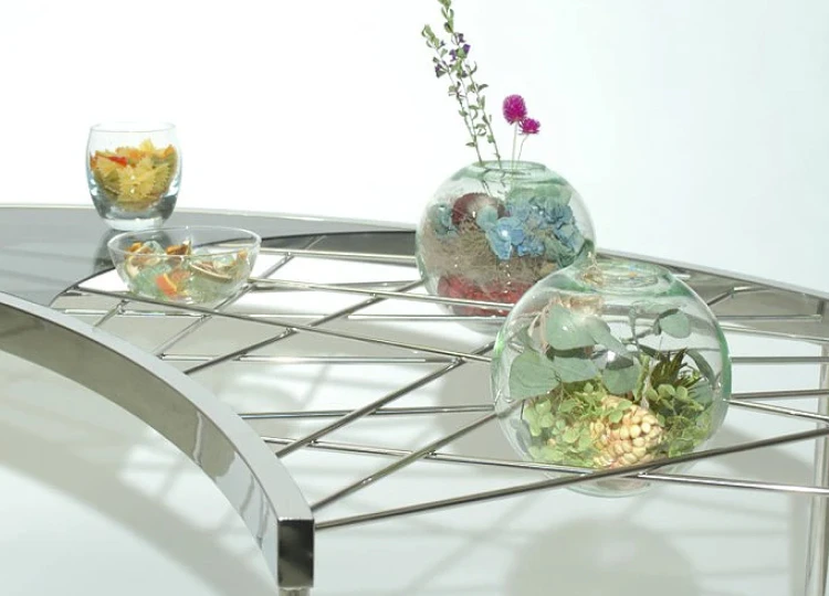 店舗内に設置された金属フレームのディスプレイ什器。内部には石や装飾素材が配置されている。